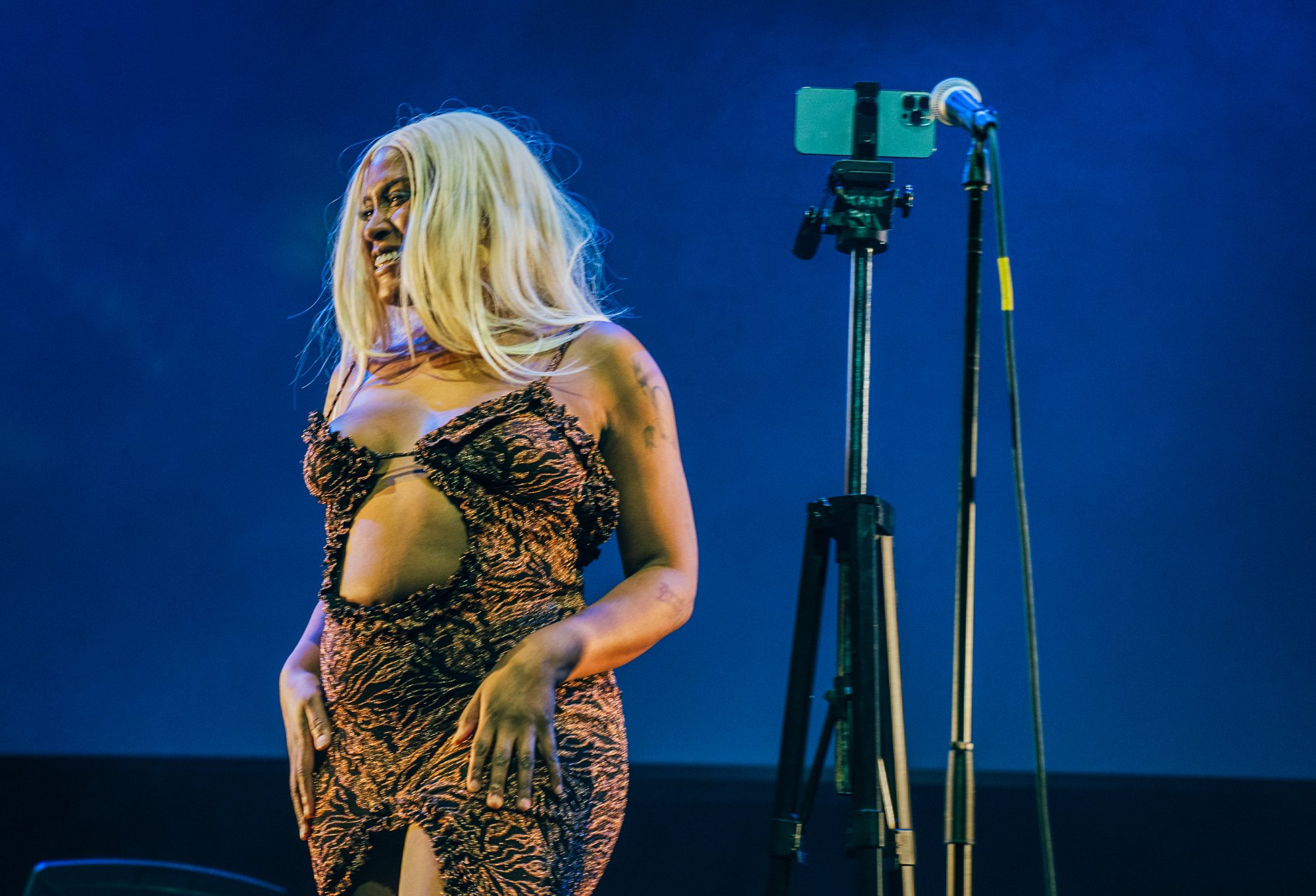 Live-stream setup — phone on tripod, Mandy performing to camera and audience